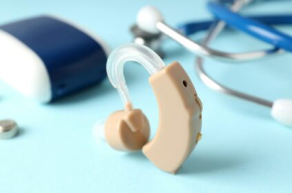 Concept of health care with hearing aid on blue background