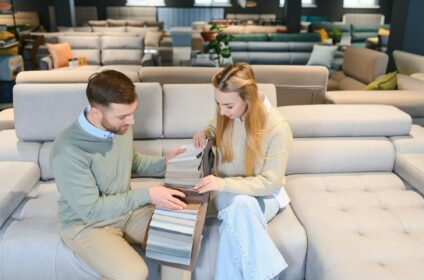 Couple choosing sofa in furniture store