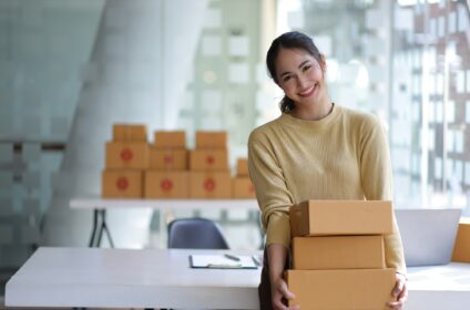 Freelance Asian woman small business entrepreneur SME working with box at home.