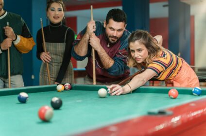 Friends having fun playing pool in arcade - Fun times with friends at the arcade