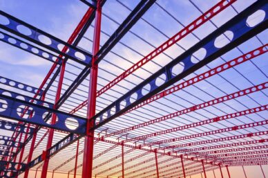 Metal castellated beam structure of large industrial building in construction site at sunset time