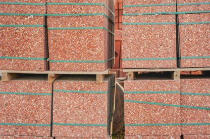 Red paving slabs on pallets in storage.