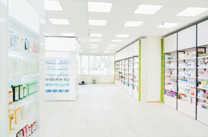 Spacious modern new white drugstore pharmacy chemist`s store with shelves full of medicines, pills
