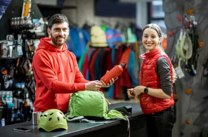 Woman with salesperson at the counter of sports shop